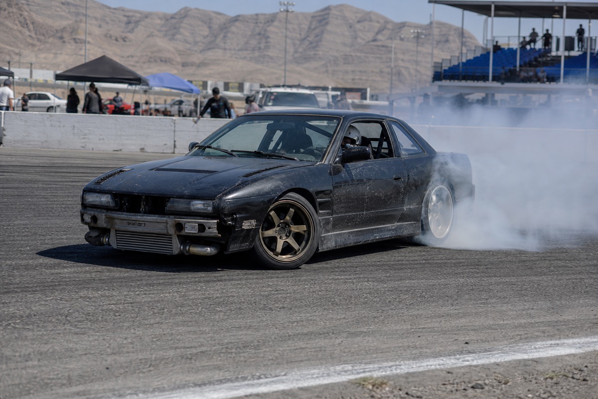 Muscle car drifting sideways in tire smoke on the Las Vegas track