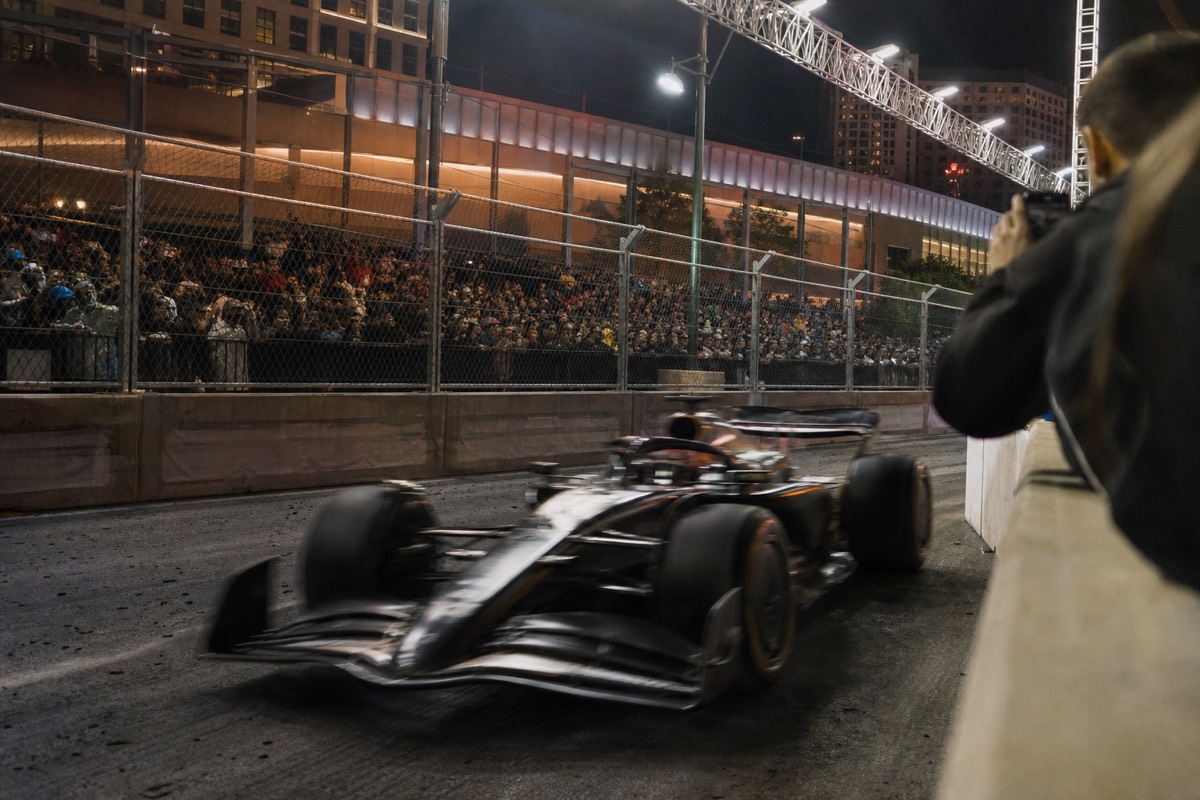 Formula-style race car cornering on a neon-lit Las Vegas street circuit at night