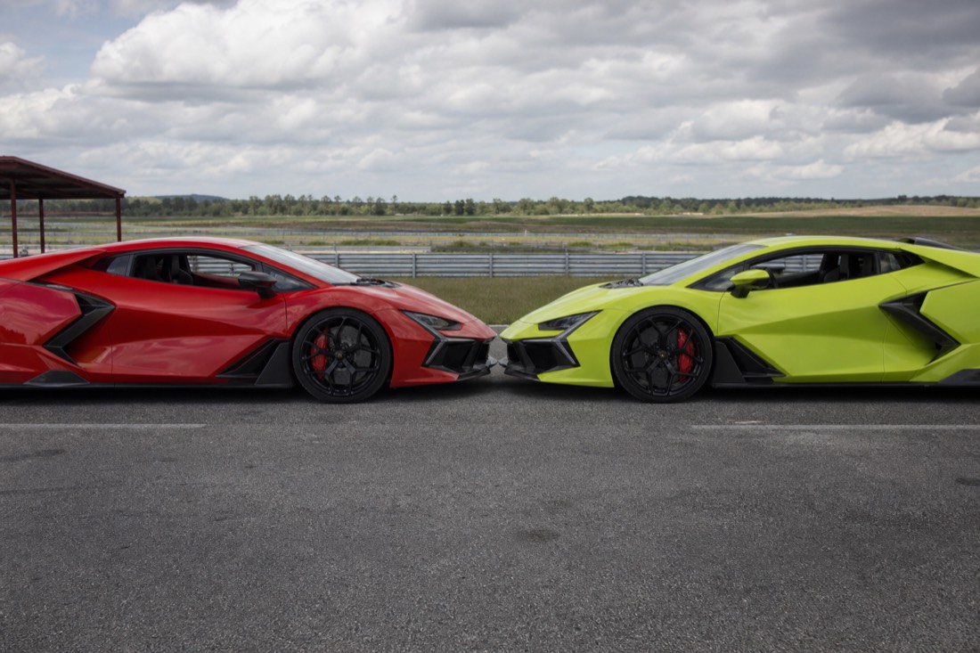 A red and a green mid-engine exotic supercar parked nose to nose