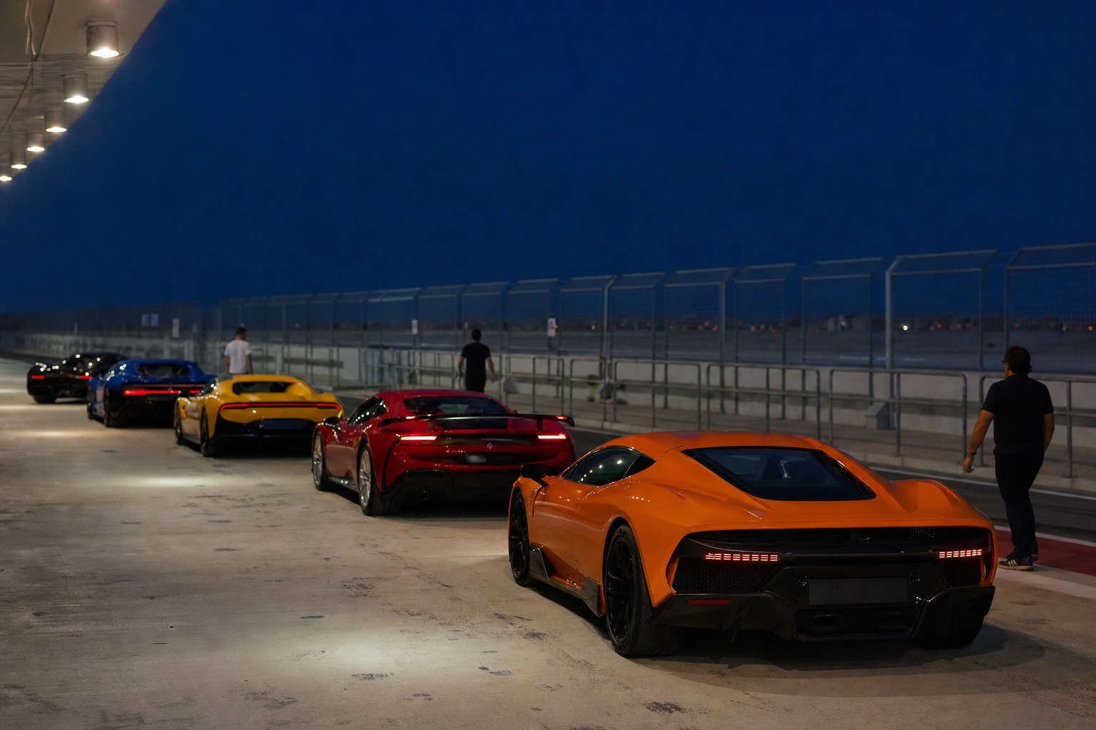 Row of exotic supercars in the pit lane at the Las Vegas track